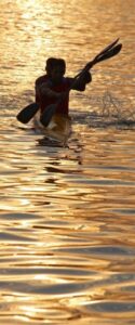 Two men canoeing at sunset.